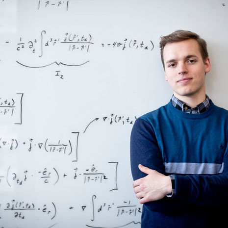 Marcus Forst in front of a whiteboard filled with equations